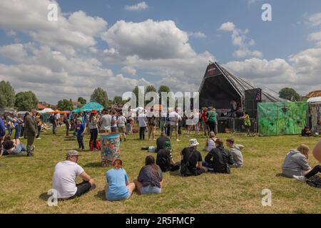 Cambridge, Royaume-Uni. 3 juin 2023. Les festivaliers se réunissent à Midsummer Common pour la Foire de la fraise, célèbre fête gratuite d'une journée de la musique, des arts et de la communauté de Cambridge. Une foule animée regarde des spectacles sur une scène extérieure, entourée de décorations colorées, de tentes et d'arbres sous un ciel partiellement nuageux. La Foire aux fraises de 2023. Penelope Barritt/Alamy Live News Banque D'Images