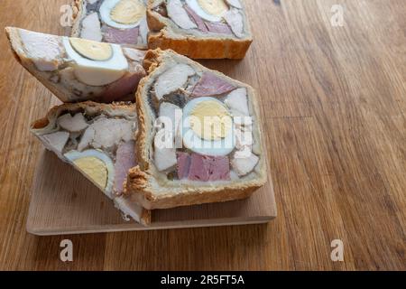 Une délicieuse portion de jambon de poulet et de tarte aux œufs mettant en valeur l'appétissante combinaison de viande cuite et d'œuf dur. Banque D'Images