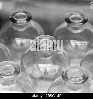 Les bouteilles avec un rebord épais sur le cou se tiennent en rangées derrière et à côté les unes des autres. Banque D'Images