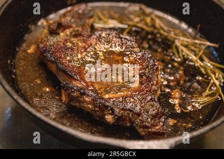 Rib Eye en fonte cuit sur une cuisinière Banque D'Images