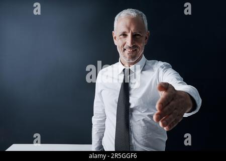 Vous souhaite la bienvenue dans l'entreprise. Portrait court d'un homme d'affaires mature vous offrant sa main d'accord. Banque D'Images