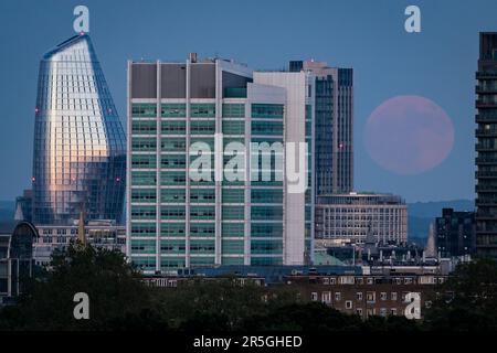 La vue de Primrose Hill à Londres de la pleine lune, également connue sous le nom de Strawberry Moon qui s'élève au-dessus de la ville de Londres. Date de la photo: Samedi 3 juin 2023. Banque D'Images