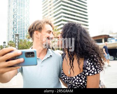 Sourire divers hétérosexuels jeunes couples faisant un selfie pendant des vacances dans une ville Banque D'Images