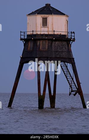 Dovercourt Essex, Royaume-Uni. 3rd juin 2023. La Strawberry Moon s'élève derrière le phare inférieur de Dovercourt dans l'Essex. La pleine Lune de juin est appelée la Lune des fraises, non pas à cause de sa couleur, mais parce que les tribus algonquines d'Amérique du Nord l'ont nommée en raison de sa présence pendant la saison de récolte des fraises. Crédit : MARTIN DALTON/Alay Live News Banque D'Images