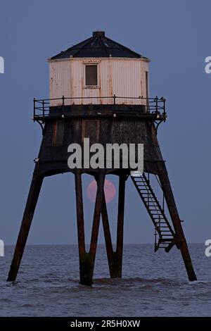 Dovercourt Essex, Royaume-Uni. 3rd juin 2023. La Strawberry Moon s'élève derrière le phare inférieur de Dovercourt dans l'Essex. La pleine Lune de juin est appelée la Lune des fraises, non pas à cause de sa couleur, mais parce que les tribus algonquines d'Amérique du Nord l'ont nommée en raison de sa présence pendant la saison de récolte des fraises. Crédit : MARTIN DALTON/Alay Live News Banque D'Images