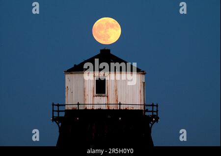 Dovercourt Essex, Royaume-Uni. 3rd juin 2023. La Strawberry Moon s'élève derrière le phare inférieur de Dovercourt dans l'Essex. La pleine Lune de juin est appelée la Lune des fraises, non pas à cause de sa couleur, mais parce que les tribus algonquines d'Amérique du Nord l'ont nommée en raison de sa présence pendant la saison de récolte des fraises. Crédit : MARTIN DALTON/Alay Live News Banque D'Images