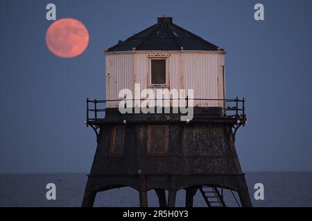 Dovercourt Essex, Royaume-Uni. 3rd juin 2023. La Strawberry Moon s'élève derrière le phare inférieur de Dovercourt dans l'Essex. La pleine Lune de juin est appelée la Lune des fraises, non pas à cause de sa couleur, mais parce que les tribus algonquines d'Amérique du Nord l'ont nommée en raison de sa présence pendant la saison de récolte des fraises. Crédit : MARTIN DALTON/Alay Live News Banque D'Images