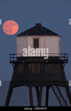 Dovercourt Essex, Royaume-Uni. 3rd juin 2023. La Strawberry Moon s'élève derrière le phare inférieur de Dovercourt dans l'Essex. La pleine Lune de juin est appelée la Lune des fraises, non pas à cause de sa couleur, mais parce que les tribus algonquines d'Amérique du Nord l'ont nommée en raison de sa présence pendant la saison de récolte des fraises. Crédit : MARTIN DALTON/Alay Live News Banque D'Images