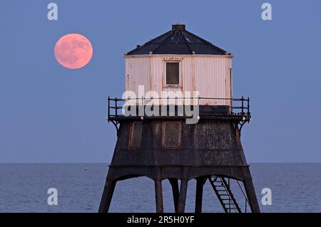 Dovercourt Essex, Royaume-Uni. 3rd juin 2023. La Strawberry Moon s'élève derrière le phare inférieur de Dovercourt dans l'Essex. La pleine Lune de juin est appelée la Lune des fraises, non pas à cause de sa couleur, mais parce que les tribus algonquines d'Amérique du Nord l'ont nommée en raison de sa présence pendant la saison de récolte des fraises. Crédit : MARTIN DALTON/Alay Live News Banque D'Images