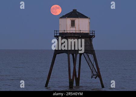 Dovercourt Essex, Royaume-Uni. 3rd juin 2023. La Strawberry Moon s'élève derrière le phare inférieur de Dovercourt dans l'Essex. La pleine Lune de juin est appelée la Lune des fraises, non pas à cause de sa couleur, mais parce que les tribus algonquines d'Amérique du Nord l'ont nommée en raison de sa présence pendant la saison de récolte des fraises. Crédit : MARTIN DALTON/Alay Live News Banque D'Images