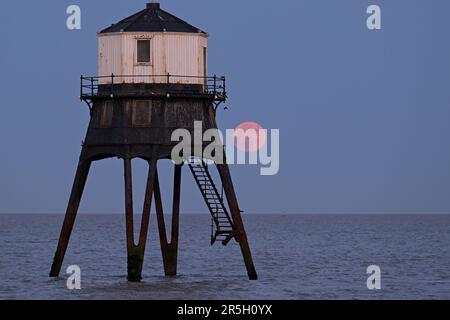 Dovercourt Essex, Royaume-Uni. 3rd juin 2023. La Strawberry Moon s'élève derrière le phare inférieur de Dovercourt dans l'Essex. La pleine Lune de juin est appelée la Lune des fraises, non pas à cause de sa couleur, mais parce que les tribus algonquines d'Amérique du Nord l'ont nommée en raison de sa présence pendant la saison de récolte des fraises. Crédit : MARTIN DALTON/Alay Live News Banque D'Images