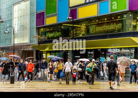 Gens ordinaires de Hong Kong traverser Une route pendant Un orage , Causeway Bay, Hong Kong, Chine. Banque D'Images