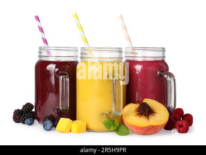 Différents smoothies savoureux dans des pots de maçon isolés sur du blanc Banque D'Images