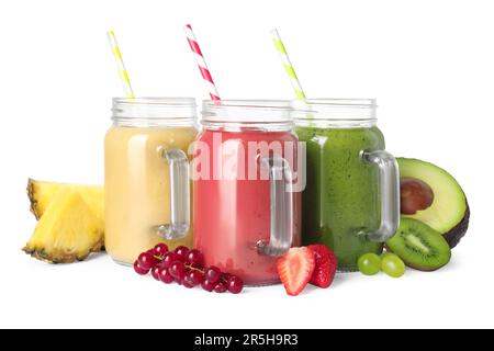 Différents smoothies savoureux dans des pots de maçon isolés sur du blanc Banque D'Images