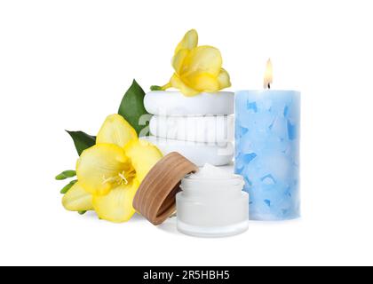 Belle composition avec pot de crème corporelle, fleurs, pierres et bougie sur fond blanc. Soins thermaux Banque D'Images