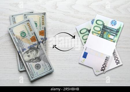 Bureau de change. Entourez les flèches entre les billets en dollars et en euros sur fond blanc en bois, sur fond plat Banque D'Images