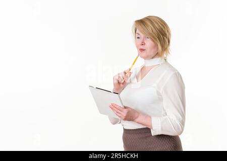 Femme d'affaires attentionnés avec un crayon et une planchette à pince qui regarde loin. Concept résoudre le problème, élaborer la stratégie et la planification de l'entreprise Banque D'Images