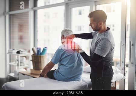 Relâchement de la tension dans tout le corps. un jeune physiothérapeute de sexe masculin aide un patient âgé à se rétablir. Banque D'Images