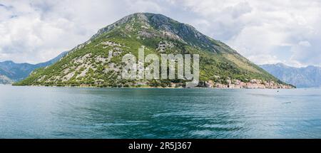Une des montagnes qui s'aligne sur la baie de Kotor tours haut au-dessus du joli village de Perast au Monténégro. Banque D'Images