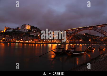 Vue sur la région de Ribeira - Porto traversant le Douro la nuit. Remarque légère motion blurr sur le port traditionnel transportant des bateaux Rabelo. Banque D'Images