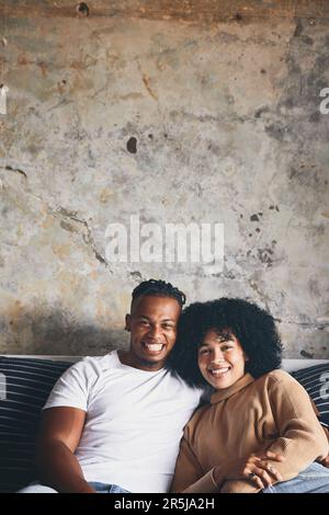 Rien n'est plus unique... rester à la maison pour un vrai confort. Portrait d'un jeune couple qui se détend ensemble sur un canapé à la maison. Banque D'Images