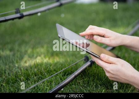 Farmer contrôle le système d'irrigation goutte-à-goutte avec la tablette numérique Banque D'Images