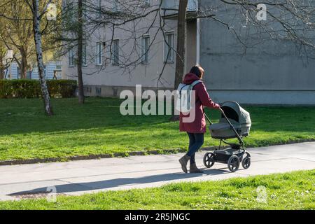 vienne, autriche. 04 avril 2023 promenade sereine au printemps une femme avec une poussette embrassant la belle après-midi dans le parc Banque D'Images