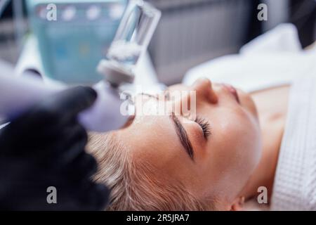 Femme caucasienne obtenant la procédure de peeling du visage dans une clinique de beauté, gros plan. Soin liquide au gaz du visage rajeunissant. Opération de nettoyage de la peau Hydro air Banque D'Images