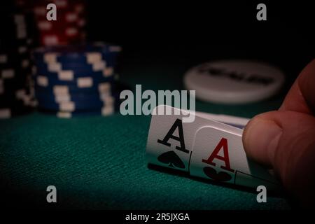 Une table de poker avec des jetons, un bouton revendeur et deux as dans la main du joueur Banque D'Images