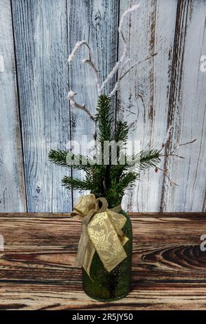 Un vase décoratif avec un noeud contenant des aiguilles de pin et des branches enneigées Banque D'Images