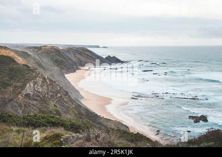 La côte ouest du Portugal est bordée de falaises rocheuses et de plages de sable dans la région d'Odemira. Flâner le long du sentier des pêcheurs les jours de pluie. Banque D'Images