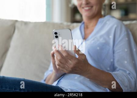 Gros plan du smartphone blanc dans les mains de femmes matures Banque D'Images