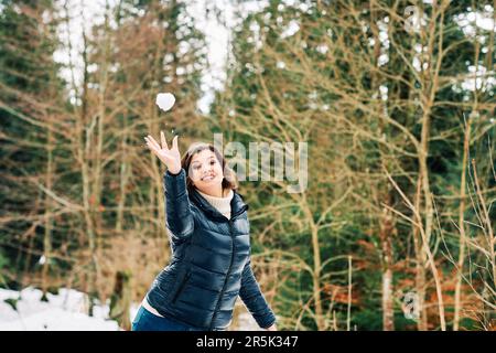 Portraot extérieur de la jeune femme heureuse de lancer boule de neige Banque D'Images