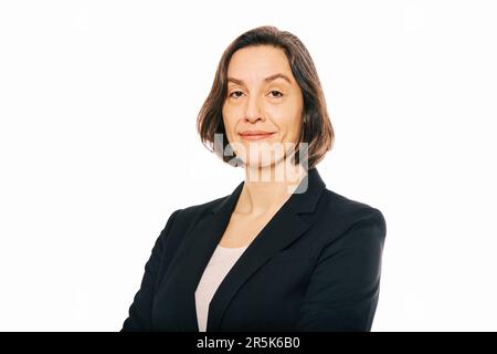 Studio portrait de femme de 45 - 50 ans posant sur fond blanc, portant une veste noire Banque D'Images