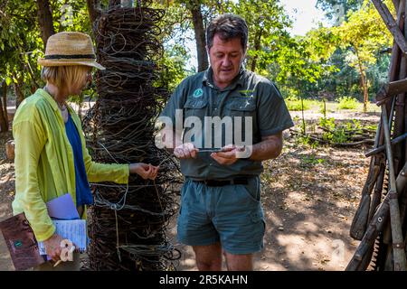 Armes confisquées et pièges utilisés par les braconniers dans la région du parc national de Majete, Malawi. Réserve faunique de Majete, le directeur du parc John Adendorff montre à la journaliste Angela Berg comment les braconniers posent des pièges métalliques Banque D'Images