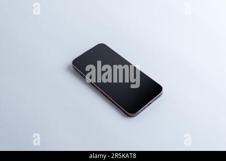 Téléphone propre et moderne sur un bureau gris. La vue isométrique de l'application présente une esthétique élégante et professionnelle Banque D'Images