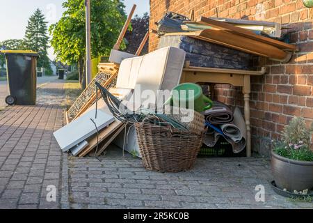 Tas de déchets volumineux avec matelas, cadre de lit, table et placards au bord de la route Banque D'Images