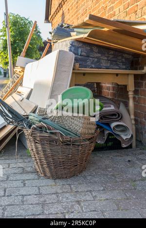 Tas de déchets volumineux avec matelas, cadre de lit, table et placards au bord de la route Banque D'Images