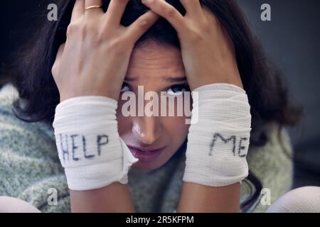 Dépression, poignet et femme avec l'aide sur le bandage pour le suicide, l'automutilation ou la personne en crise de santé mentale sombre. Portrait, fille et blessure de Banque D'Images