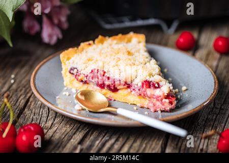 Tarte à la crème de cerise aigre, pâtisserie à la crème et miettes, servie avec de la crème glacée à la vanille. Ambiance et décoration rustiques et moody. Banque D'Images