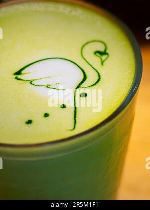 Latte art - dessin de flamants roses sur mousse avec du thé matcha chaud sur le lait de coco. Banque D'Images