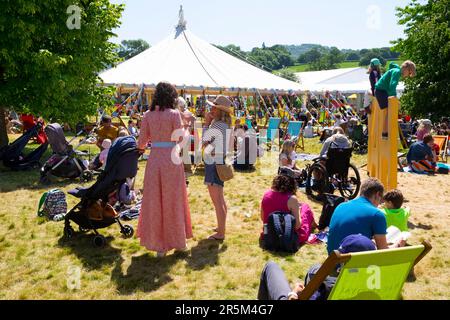 Personnes visiteurs lecteurs famille familles enfants jouant se détendre sur la pelouse au soleil au Hay Festival 2023 site Hay on Wye Wales UK KATHY DEWITT Banque D'Images