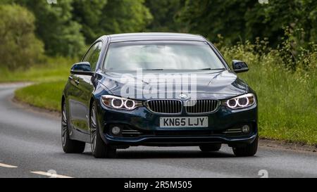 Stony Stratford, Royaume-Uni - 2 juin 2023: 2015 BMW bleue 435 voyageant sur une route de campagne anglaise Banque D'Images