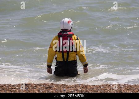 Affichage conjoint des services d'urgence axé sur la sécurité de l'eau. Les équipages et les navires de RNLI et de Coastguard démontrent le rétablissement d'une victime de la mer. Banque D'Images