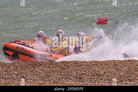 Affichage conjoint des services d'urgence axé sur la sécurité de l'eau. Les équipages et les navires de RNLI et de Coastguard démontrent le rétablissement d'une victime de la mer. Banque D'Images