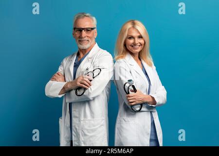 Portrait des médecins de l'homme et de la femme âgés sur fond bleu Banque D'Images