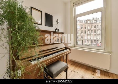 un salon avec un vieux piano et quelques plantes dans la fenêtre simh est sur le mur à côté du piano Banque D'Images