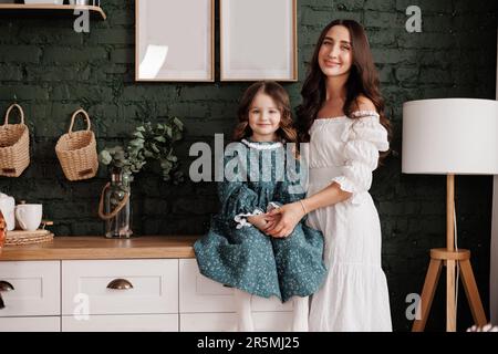 Fête des mères. Une jeune maman sensible embrasse sa petite fille adorable à la maison. Confiance, soutien et amour entre maman et enfant. Une famille aimante Banque D'Images