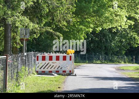 Barricade blanche rouge avec feux d'avertissement comme mesure de sécurité pour les travaux de terrassement pendant le câble et la fibre optique se trouvant sur une route de campagne, énergie, connexion Banque D'Images