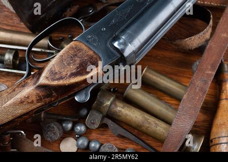 Fusil de chasse à alésage lisse avec boîtiers en laiton et accessoires pour recharger la cartouche sur une table en bois. Banque D'Images